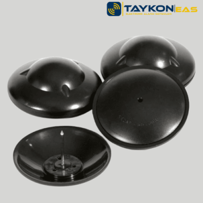 Nedap R40 Siyah – Şık ve Güçlü Alarm Etiketi Nedap R40 siyah alarm etiketi – masa üzerinde sergilenen perakende güvenlik çözümü