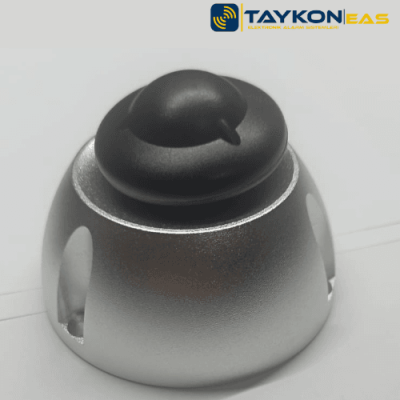 Nedap R40 Siyah – Şık ve Güçlü Alarm Etiketi Nedap R40 siyah alarm etiketi – masa üzerinde sergilenen perakende güvenlik çözümü